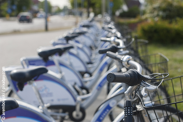 Eine Reihe von geparkten Leihfarhrädern, die blau und silber sind.